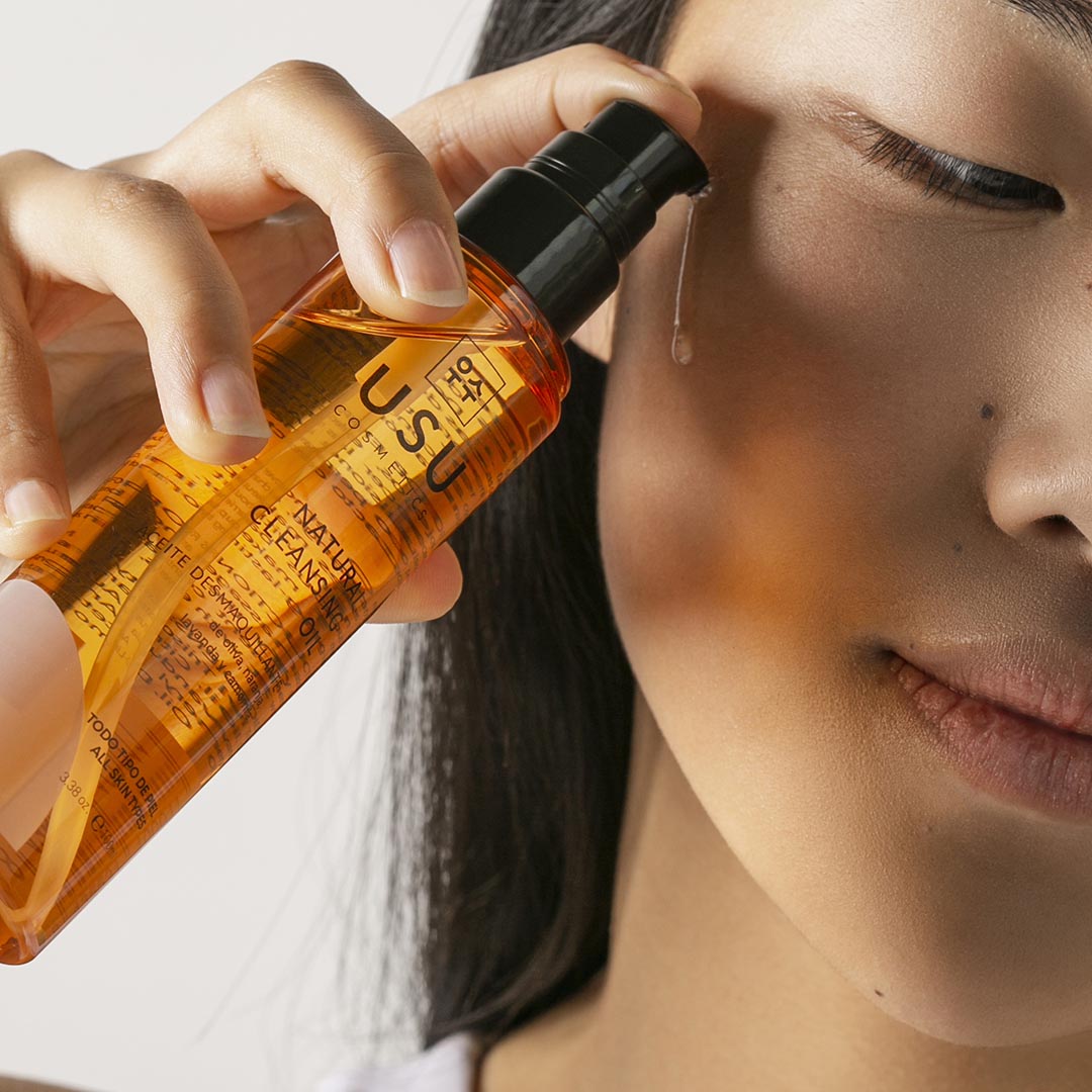 Mujer aplicando el aceite desmaquillante sobre rostro