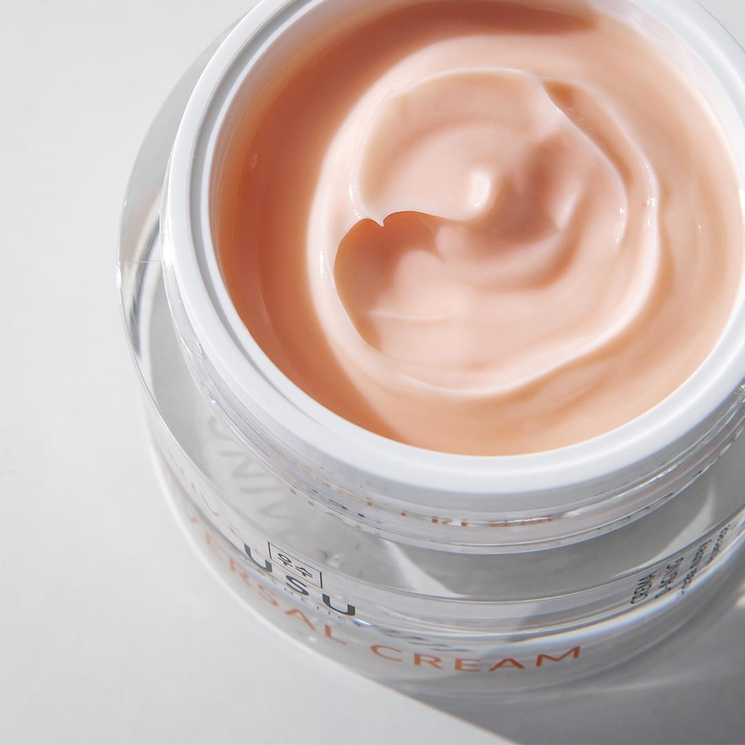 Tarro abierto de universal cream donde se muestra su textura ligera de rápida absorción.