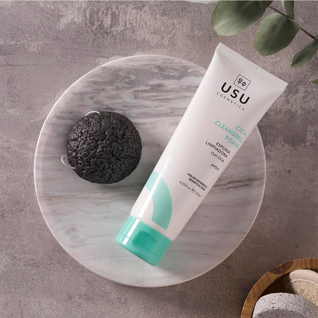 Esponja konjac purifying junto a envase de espuma limpiadora cica para limpieza facial y piel radiente